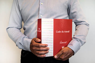 homme tenant un code du travail
